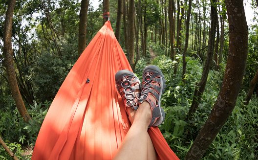 Woman hiker relaxing in hammock in rainforest