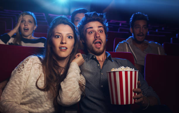 young couple at the cinema watching an horror movie - audience surprise movie theater shock imagens e fotografias de stock