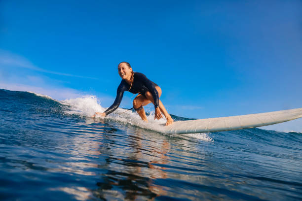 istock Female surfer on a blue wave 1213440750