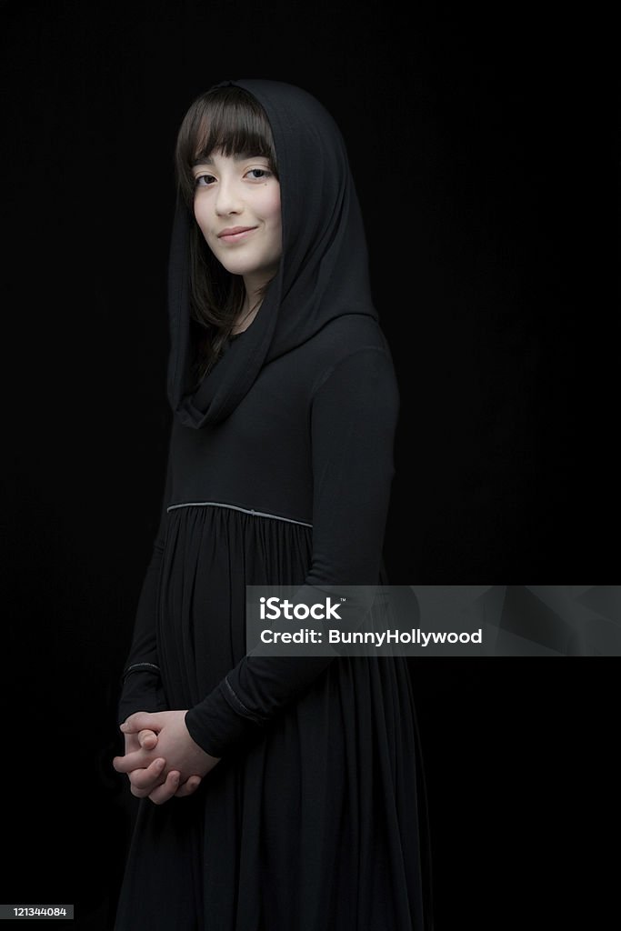 Back in black Young lady dressed in all black, set in black background Adolescence Stock Photo
