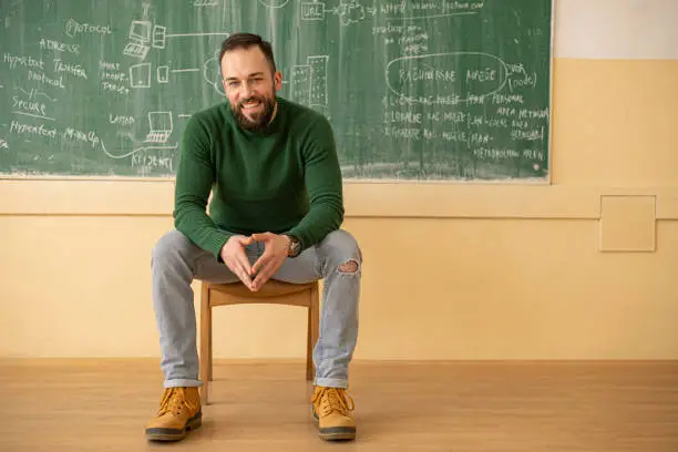Teacher sitting in front of the blackboard after his class