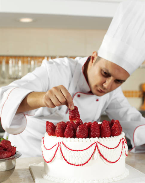 istock Baker Is Placing Strawberries On A Cake 1213443824