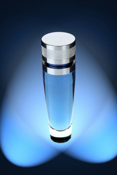 A spray bottle with hair mist or perfume on a blue background with an oval backlight. High quality photo.