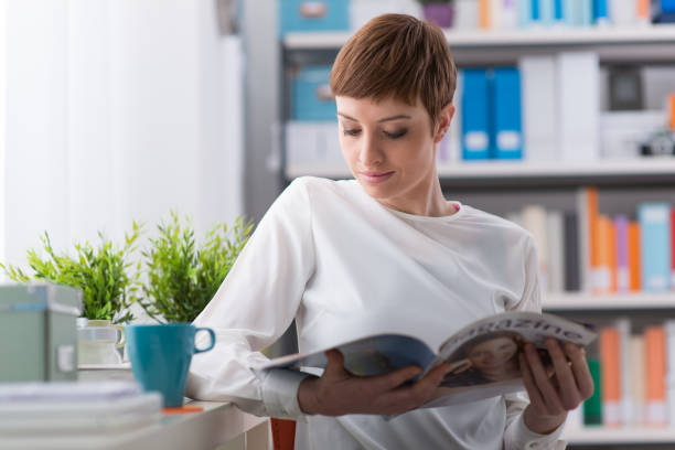 istock Woman relaxing and reading a magazine 1213449140