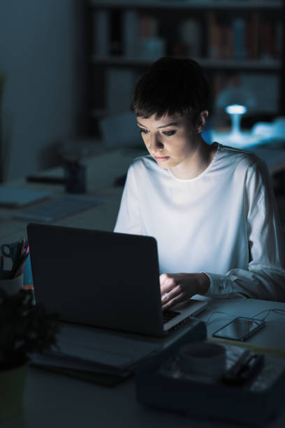 istock Woman using a laptop late at night 1213449661