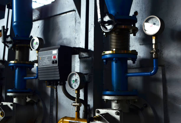 istock Automatic industrial burner control unit. Round mechanical pressure gauge for measuring pressure. Gauges in the boiler room near the heating pipes with insulation coating. Oil and gas pipeline 1213452802