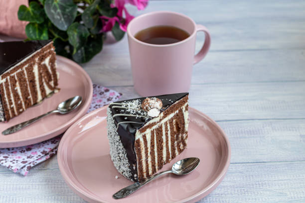 istock A slice of Zebra cake with chocolate icing. On a light background. In the background is a cup with floral tea. 1213454566