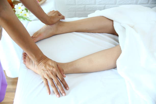 istock Masseuse use two hand to foot massage with young female 1213456515