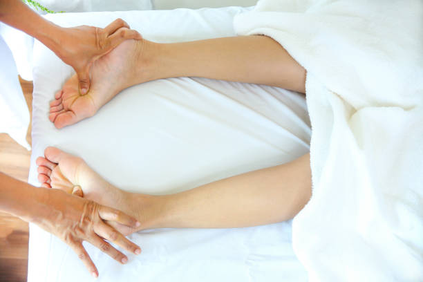 Top View close up masseuse use thump press on foot of young female for blood circulation and fatigue, copy space