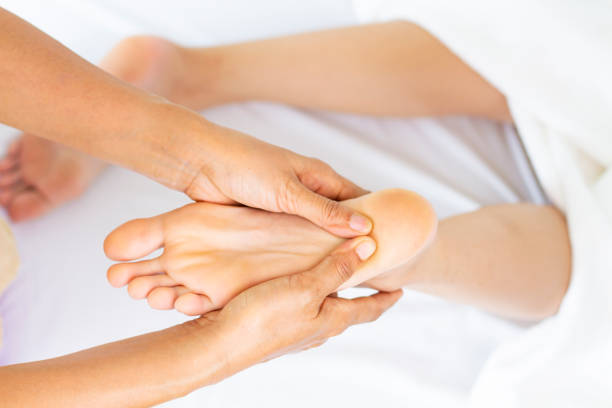 istock Masseuse use two hand to sole massage with young female 1213456556