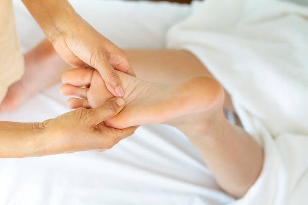 istock Masseuse use two hand to sole massage with young female 1213456570