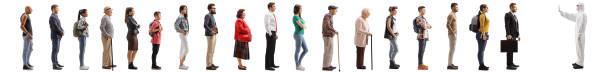 istock People waiting in line and a man in a white decontamination suit gesturing stop 1213457671