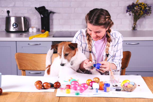 istock Girl and dog painting easter egg. 1213458768