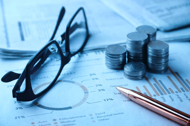 istock Pen and coins stack with glasses on document chart paper ,business concept. 1213461319