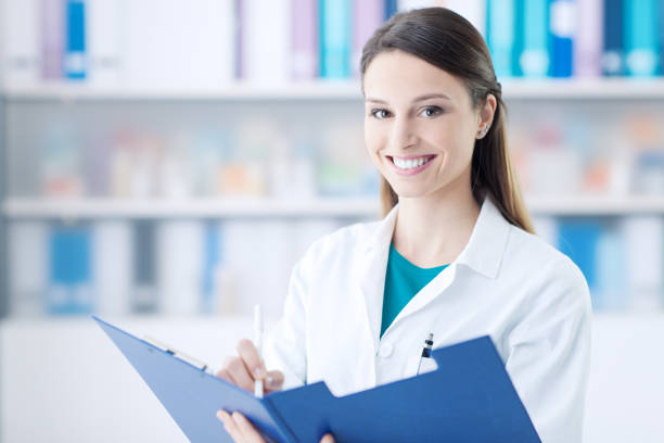 istock Smiling doctor writing on a clipboard 1213462636