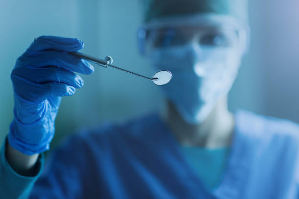 dentista femal sosteniendo un espejo bucal - medical exam dental hygiene caucasian mask fotografías e imágenes de stock