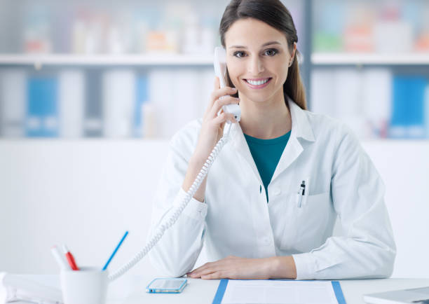 istock Smiling doctor on the phone 1213463031