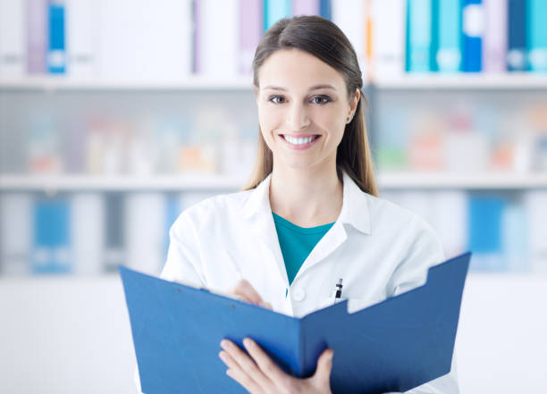 istock Smiling doctor writing on a clipboard 1213463108