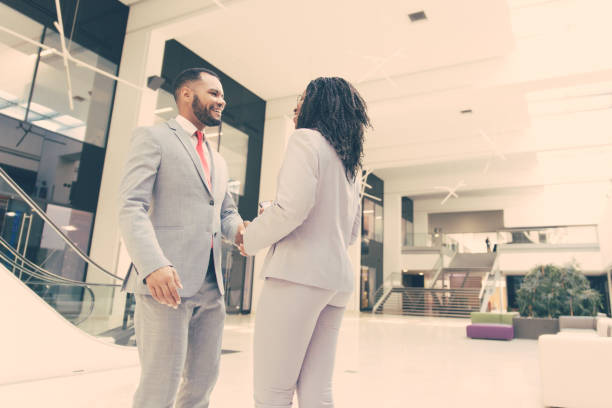 istock Business people welcoming each other in office hallway 1213463110