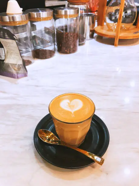 Flatwhite heartshaped froth art and gold teaspoon