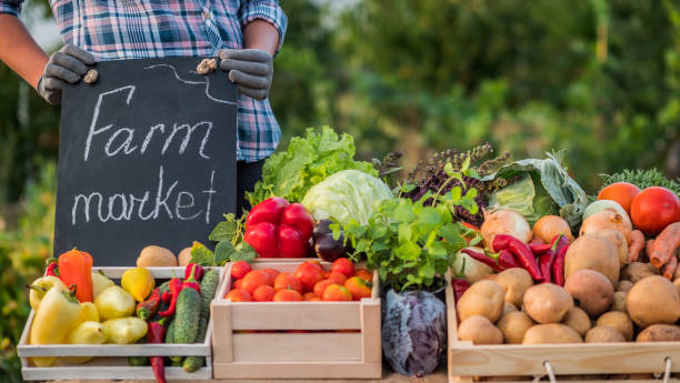 istock Farmer at the counter where he sells his vegetables 1213466625