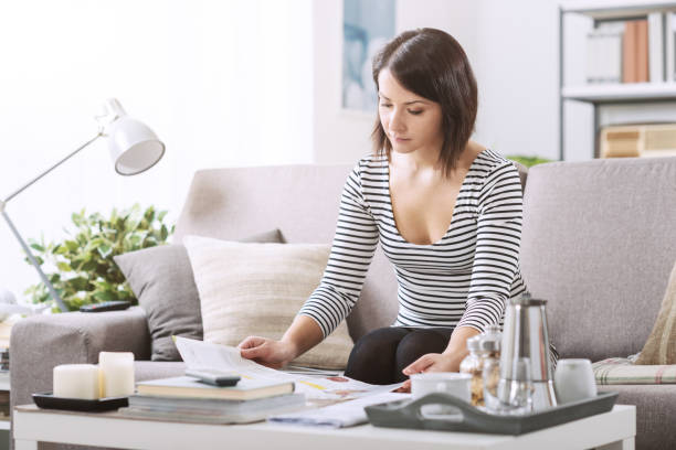 istock Woman reading a magazine on the couch 1213467093