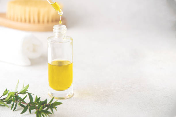 istock Selective focus on serum or massage oil falling from glass dropper 1213470680