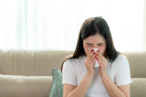 donna asiatica malata e triste con starnuti sul naso e tosse fredda sulla carta velina perché batteri influenzali e deboli o virus dal tempo della polvere o dal fumo per medico. - house dust allergy foto e immagini stock