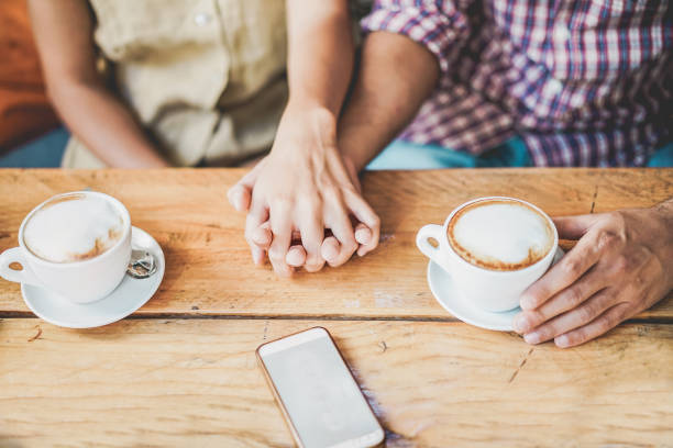 junges paar trinkt cappuccino in bar-café - menschen halten sich gegenseitig hände für zarte liebesmomente - beziehungskonzept während des reiseurlaubs - konzentrieren sie sich auf gemeinsame hände - coffee couple italy drinking stock-fotos und bilder