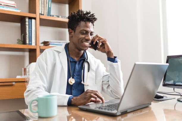 Doctor on the phone and using notebook cell phone, doctor, stethoscope, notebook, African origin doctor utensils stock pictures, royalty-free photos & images