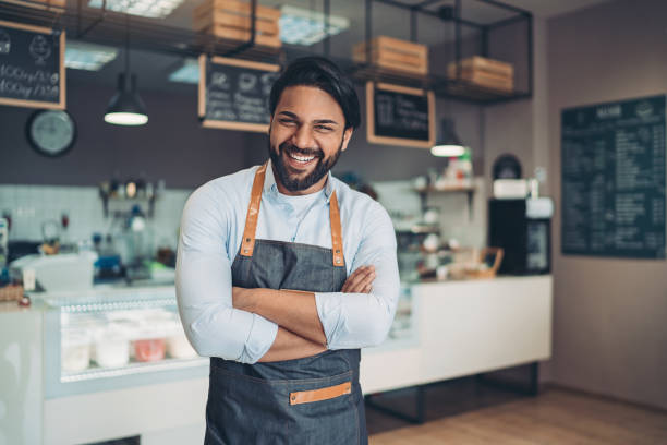 Happy coffee shop owner Portrait of a smiling young man in a cafeteria small business owner stock pictures, royalty-free photos & images
