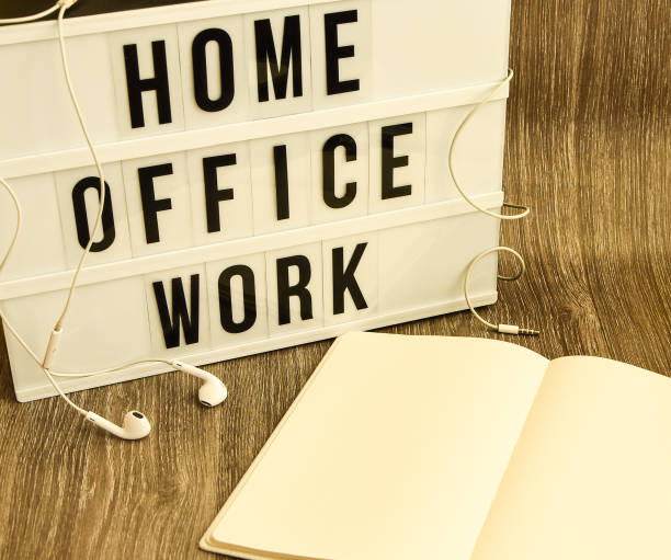 istock lightbox with text HOME OFFICE WORK with notebook pen and headphones, copy space wooden table background, quarantine and isolation HOME OFFICE 1213483689