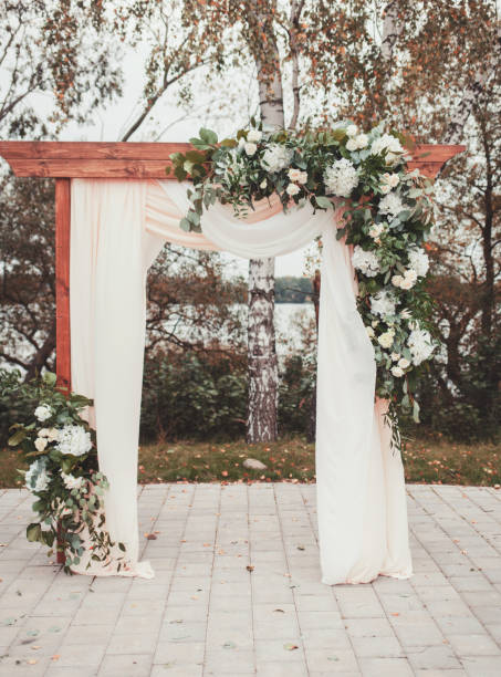 istock Wedding arch decorated with cloth and flowers 1213483726