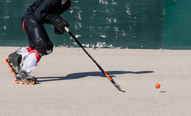 jugador de hockey sobre patines acercándose en el disco en movimiento hacia la portería - hockey sobre ruedas fotografías e imágenes de stock