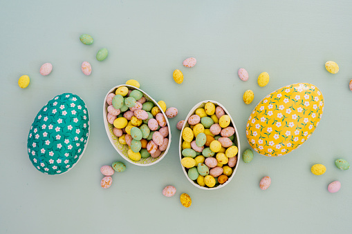 Easter eggs and candy in pastel color from above overhead 
Flat lay still life of easter egg on turquoise