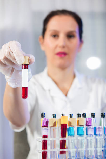 istock Lab technician assistant analyzing a blood sample in test tube at laboratory. 1213485533