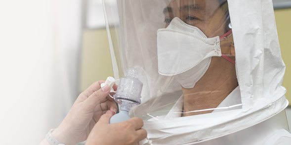 Prueba de ajuste del respirador preparada para COVID-19. Asia hombre probando el sistema repiratorio con la máscara quirúrgica N-95 para comprobar que se ajusta correctamente cara a desgaste. photo