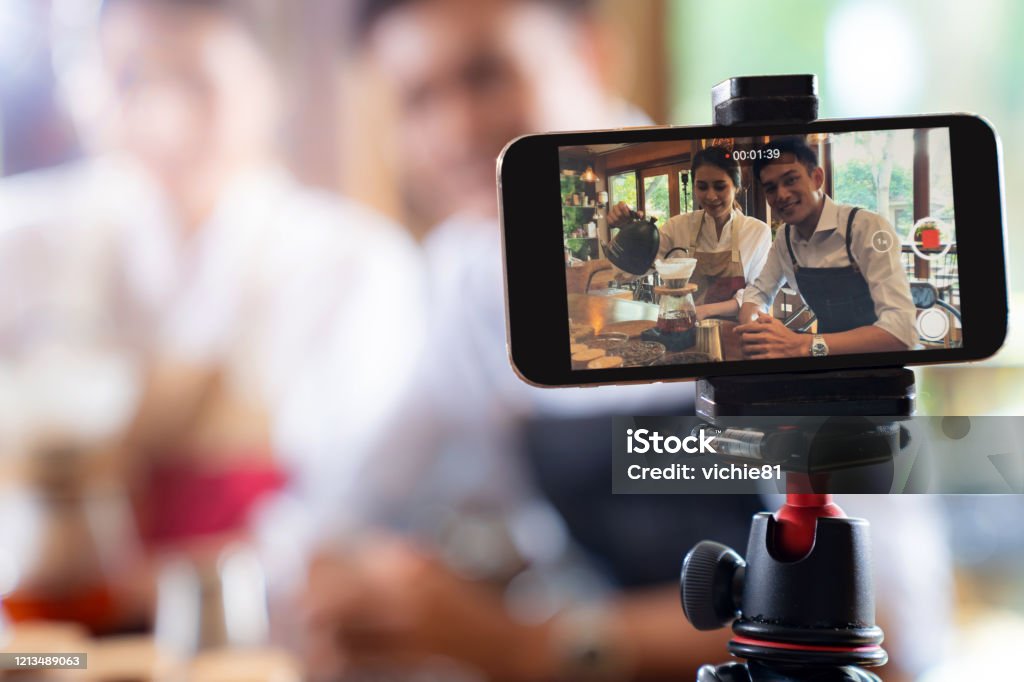 VLOG owner review cafe VLOG of  young adult asian owner entrepreneur review cafe coffee shop and live in social media for online marketing with smart phone in cafe. Using for startup of small business maketing and consumerism concept. Influencer Stock Photo