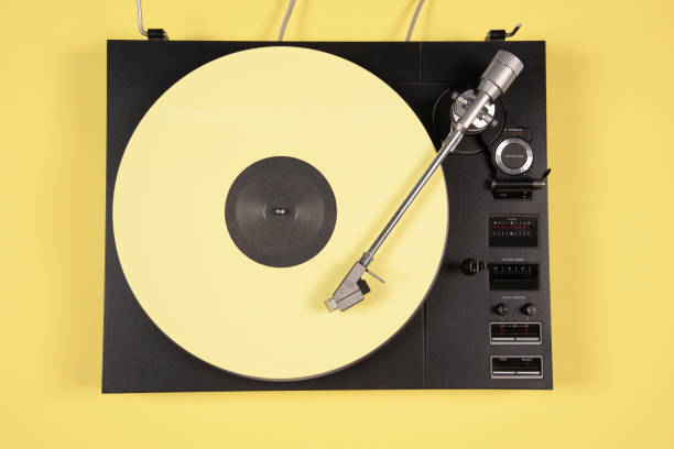 Colored vinyl records collection on a yellow background with copy space. Top view.
