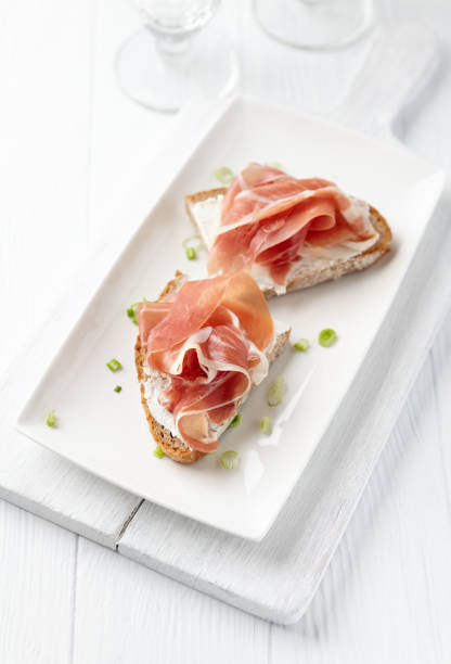 istock Sandwich with soft cheese and ham. Bright wooden background. 1213492446
