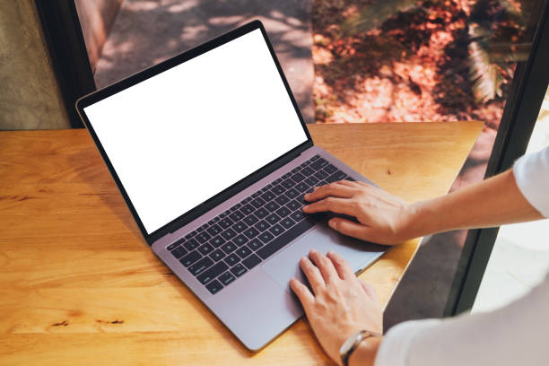 istock a woman using and typing on laptop computer with blank white desktop screen on wooden table 1213492643