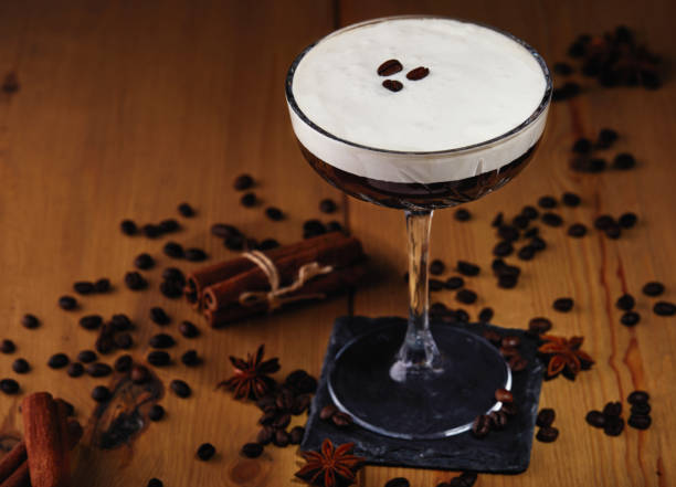 cocktail de martini d’espresso dans un verre avec des grains de café, de la cannelle et de l’anis étoilé sur un fond en bois - cocktail alcohol red martini glass photos et images de collection