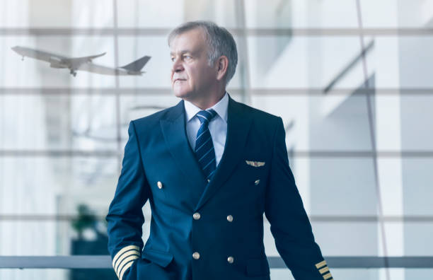 istock Experienced senior pilot pulling his luggage in the airport terminal 1213494852