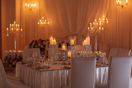 festive table decorated with flowers , cloth and candlestick. luxury wedding decoration with light. selective focus.