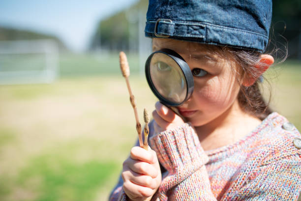 istock Girl playing with a magnifying glass 1213496717