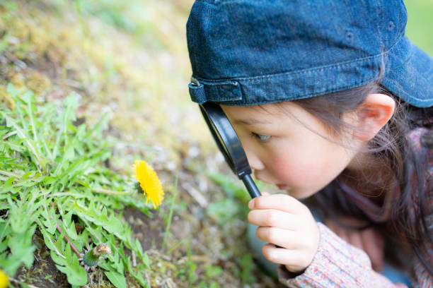 Girl playing with a magnifying glass