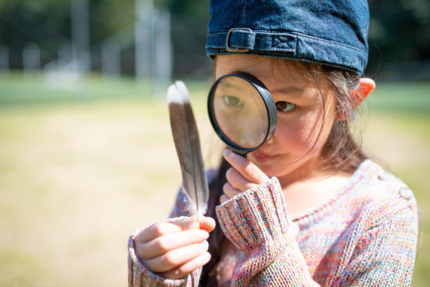 istock Girl playing with a magnifying glass 1213496773