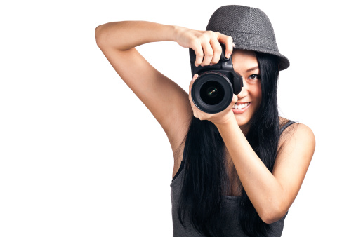 A pretty Asian girl taking photos with a DSLR and smiling.