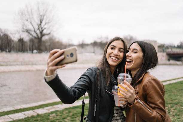 istock Happy women making selfie on river shore 1213498081