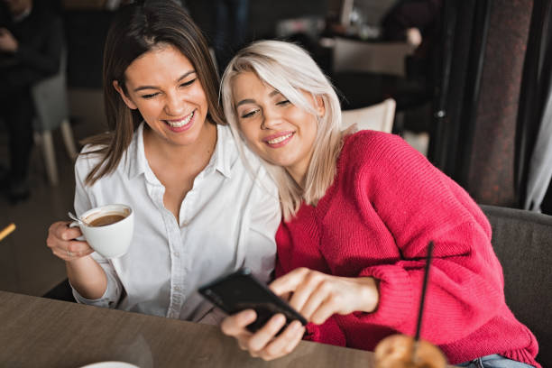 istock Young women using smart phone at coffee shop 1213498389